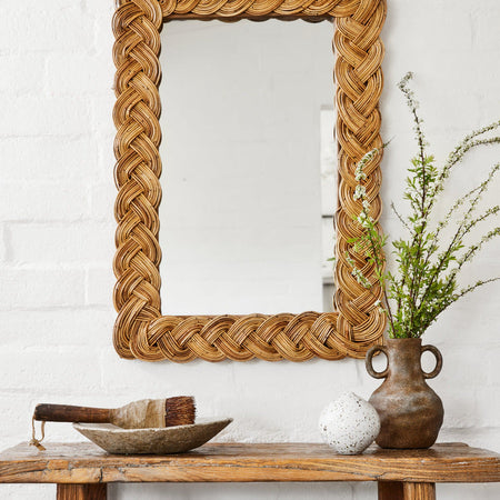 Castello Rectangular Braided Rattan Wall Mirror above rustic bench