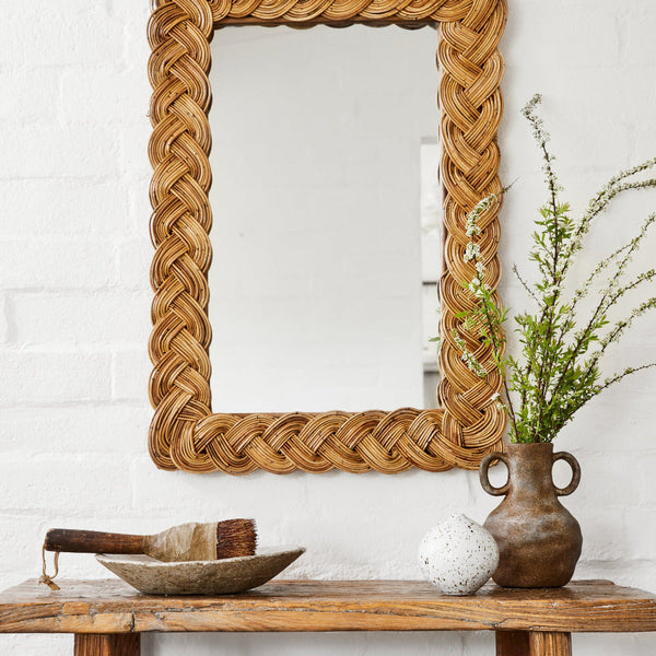 Castello Rectangular Braided Rattan Wall Mirror above rustic bench