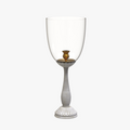 Decorative candle holder with a clear glass bowl and ribbed white base on a white background