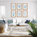 Living room with a white sofa, wooden coffee table, and framed sea fan artwork on the wall.