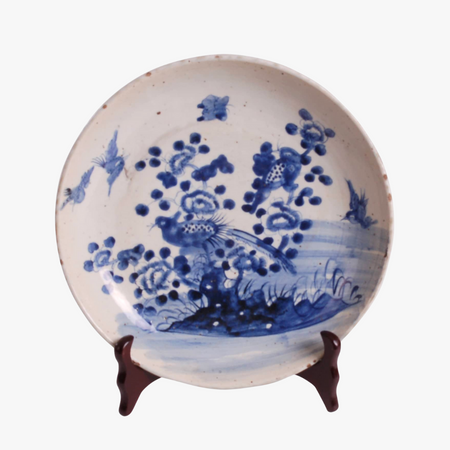 Porcelain chinoiserie style plate with blue floral and bird design on a white background