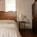 Lacoste Woven Rattan Bed  styled in rustic bedroom with wood beams