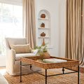 Lacoste Woven Rattan Coffee Table styled in living room with linen chairs