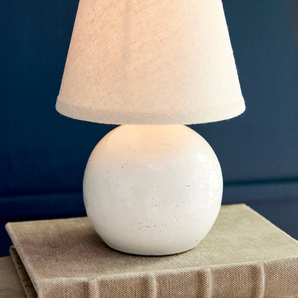 Landry Mini Lamp illuminated on book stack - closeup