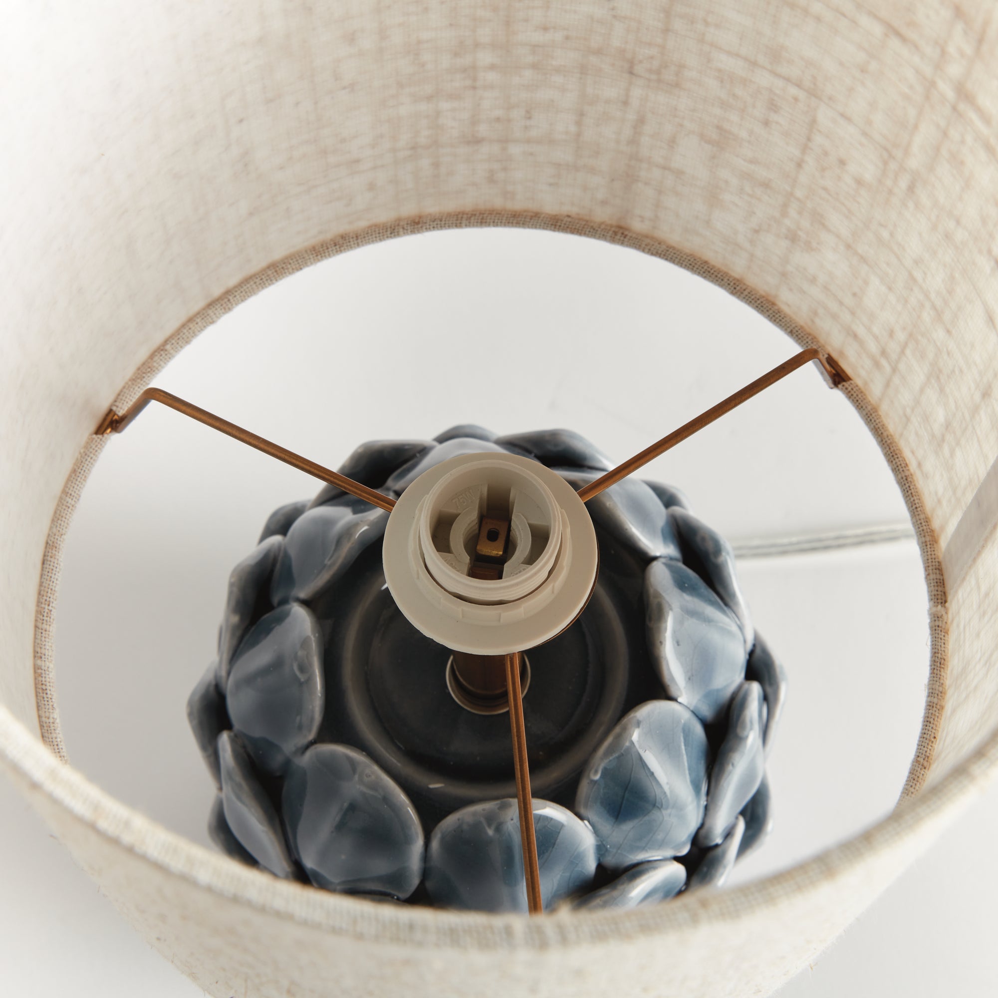 Close-up of a lampshade with a decorative lamp socket inside.