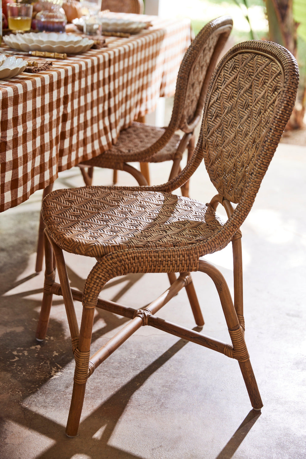Portofino Antique Brown Rattan Side Chair with gingham tablecloth