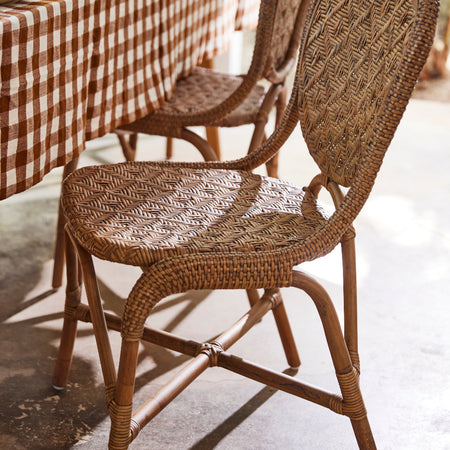 Portofino Antique Brown Rattan Side Chair with gingham tablecloth