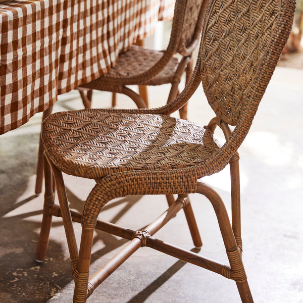 Portofino Antique Brown Rattan Side Chair with gingham tablecloth
