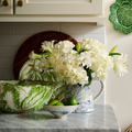 Radish Serving Bowl styled with pitcher of hydrangeas on counter