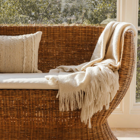 Siena Woven Rattan Settee styled with fringe blanket
