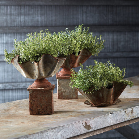 Weathered Metal Handkerchief Planter with pedestal planters on table