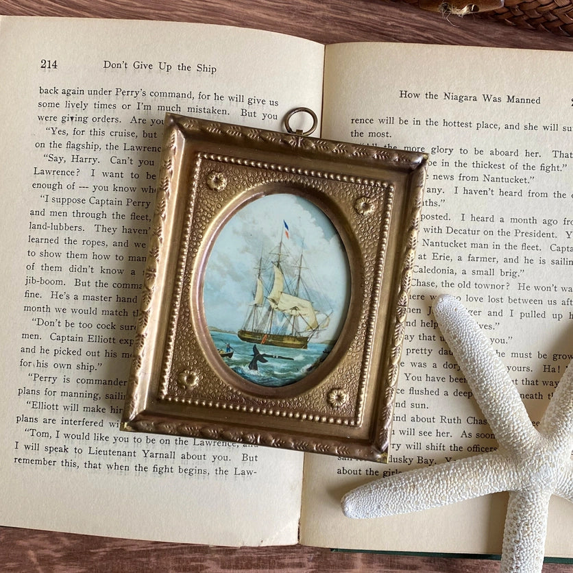 Whaling Ship Print in Antiqued Brass Frame styled with book and starfish