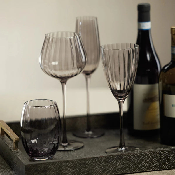 Maeve Smoke Glassware on tray with wine bottles