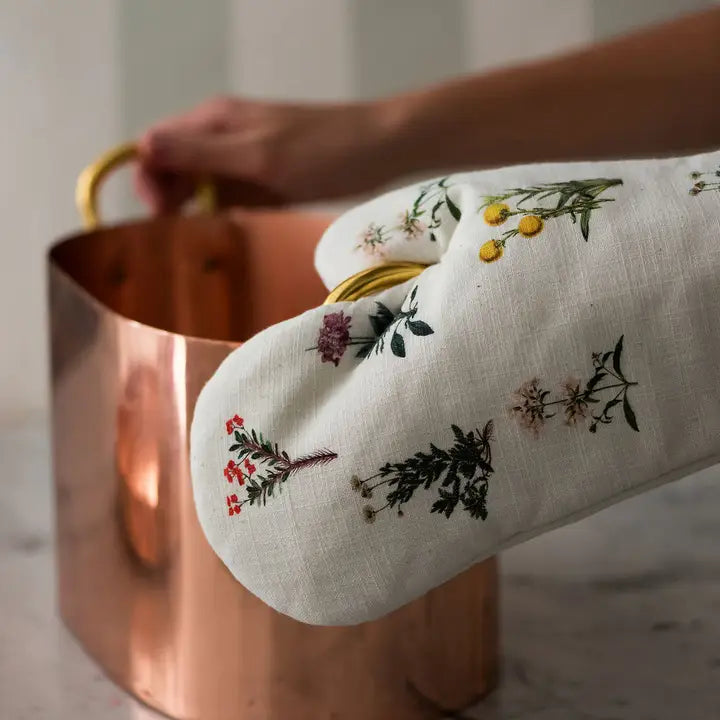 Flora Oven Mitt holding copper pot