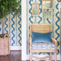 Eastham Wicker Arm Chair with custom cushion styled in blue wallpapered hallway