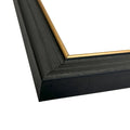 Close-up of a black picture frame with a gold corner detail on a white background