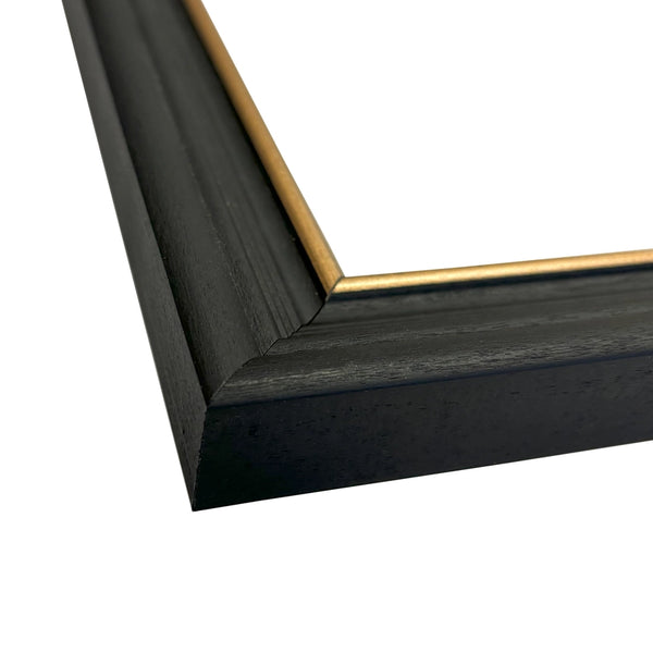 Close-up of a black picture frame with a gold corner detail on a white background